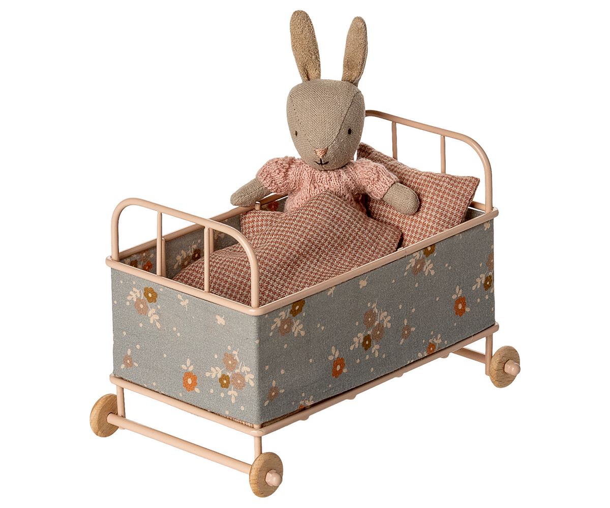 Toy rabbit in a floral-patterned bed on a white background