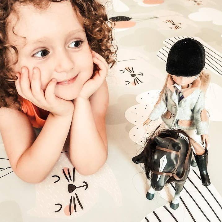 child playing with lottie doll and horse