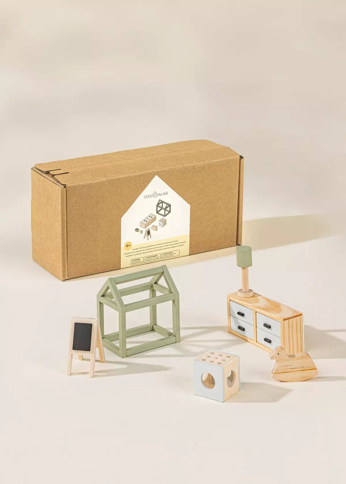 Set of wooden dollhouse toys including a house, desk, and blocks on a light background
