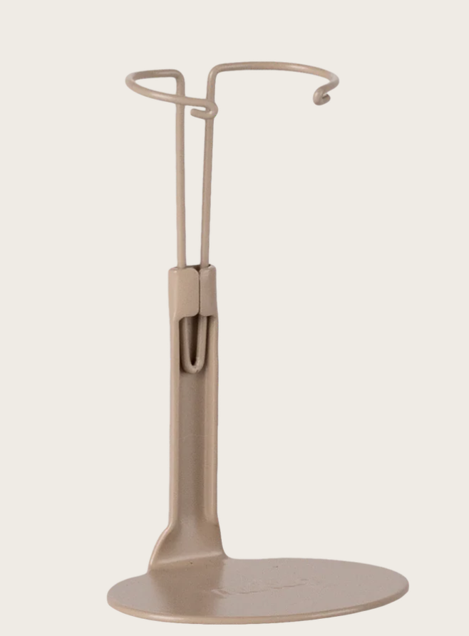 Beige stand with circular base and curved arm on a white background