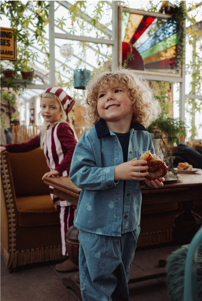 Children wearing clothing from Fliink, a Danish children's brand, inside an inviting cafe with lots of plants