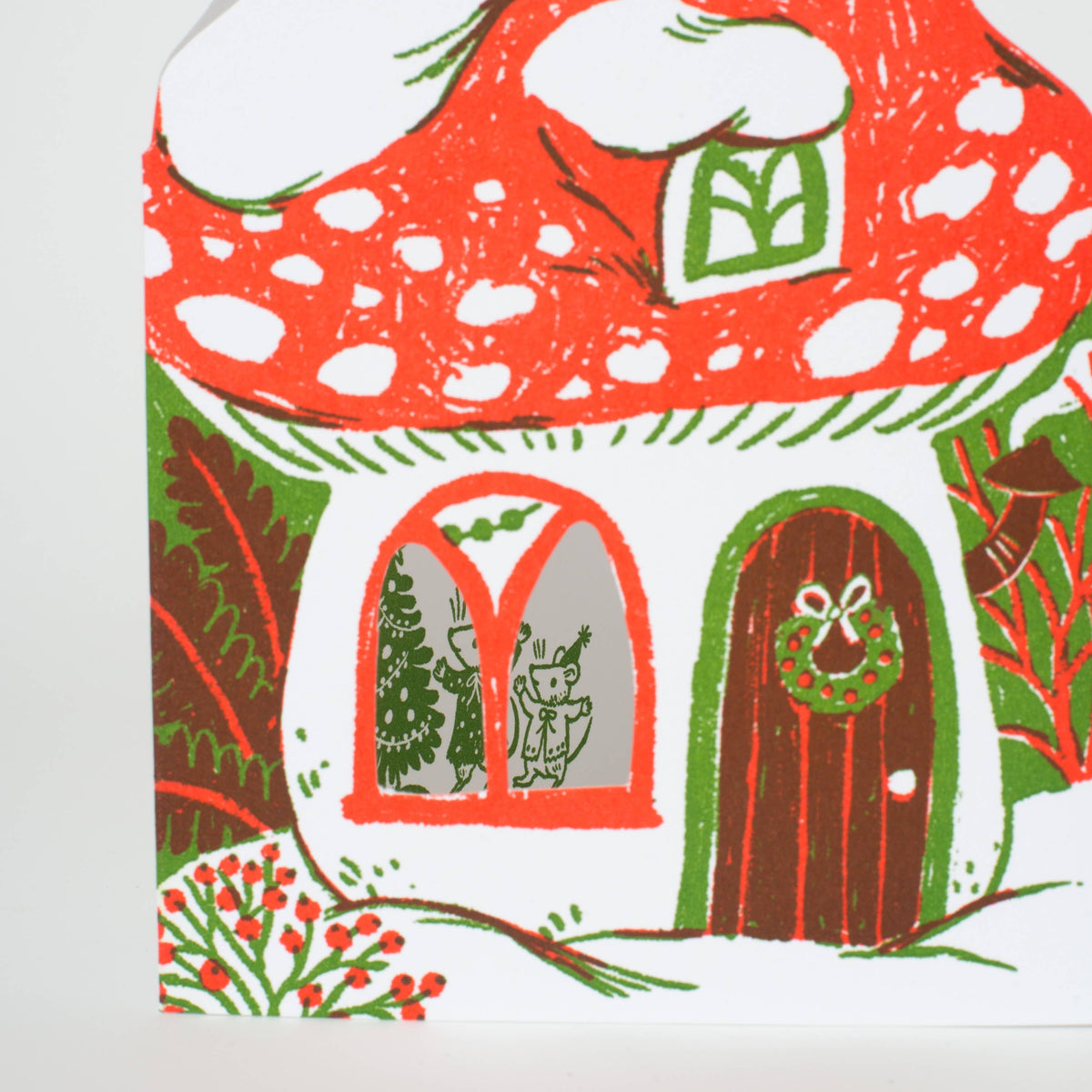 A holiday greeting card in the cutout shape of a mushroom, featuring a little mouse family trimming the tree printed inside! Letterpress printed and packaged with a kraft paper envelope.