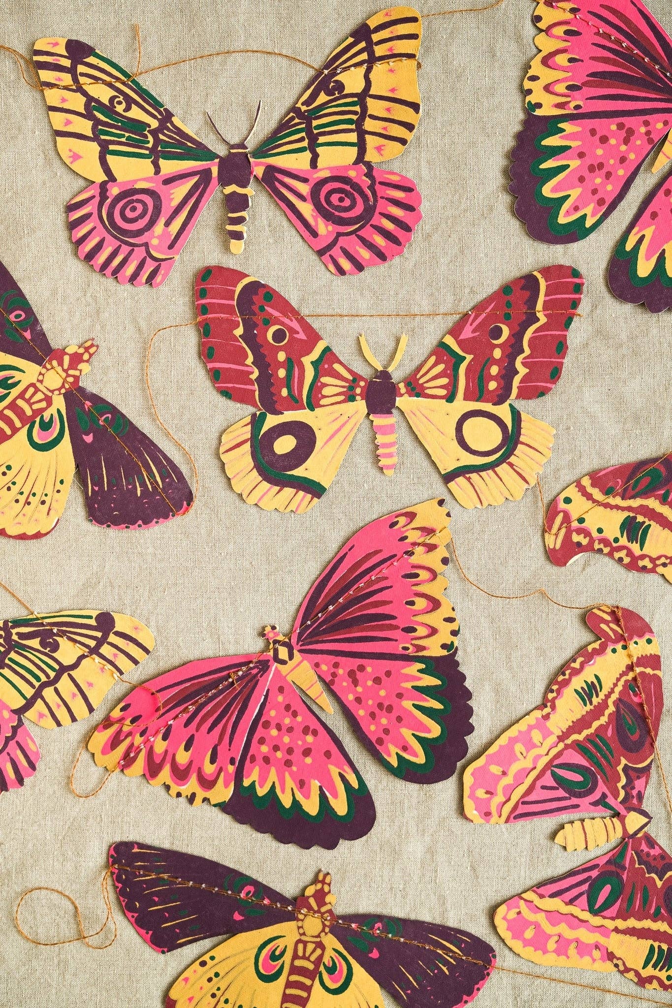 Colorful butterfly garland on a textured beige background