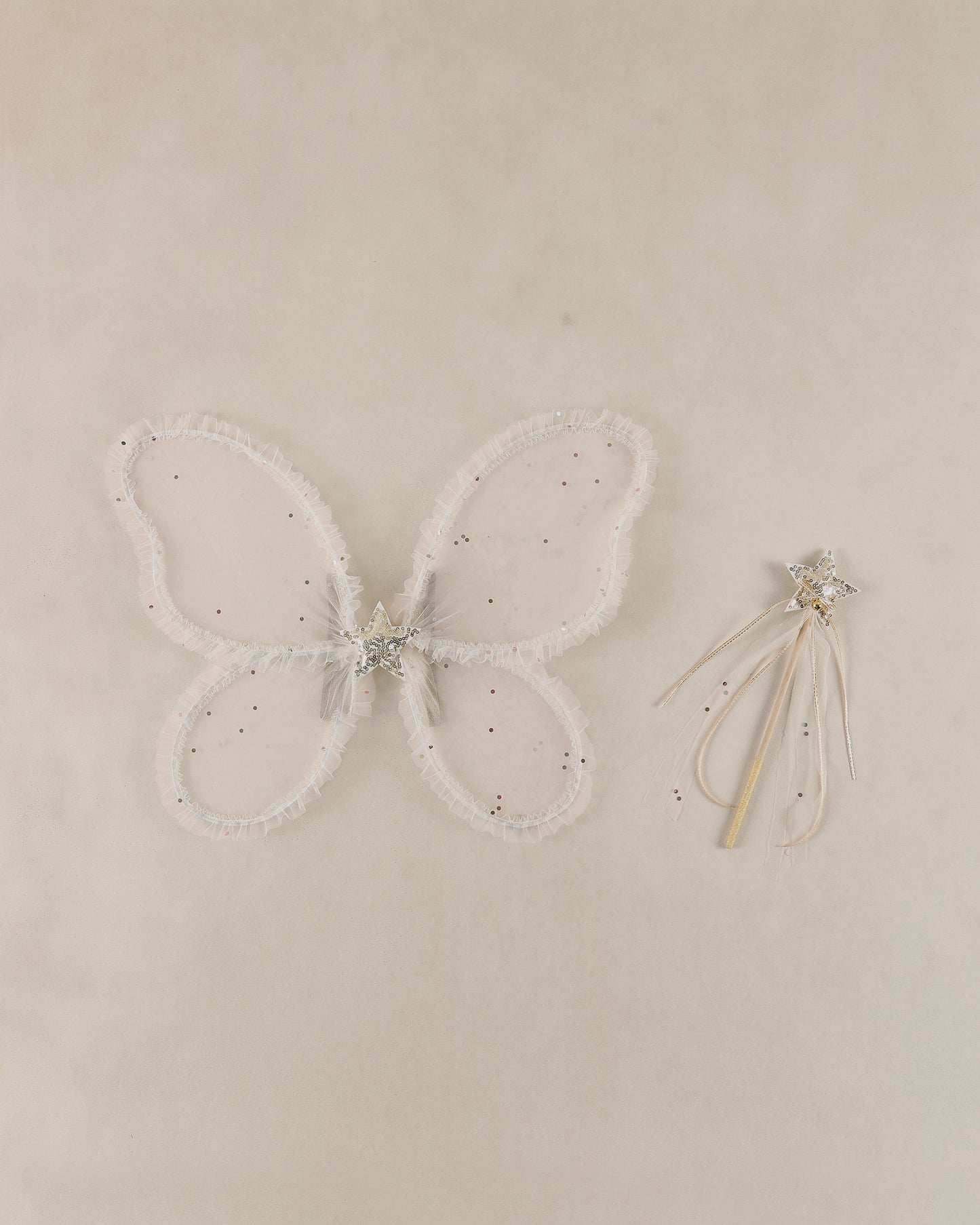 Butterfly wings with a wand on a beige background