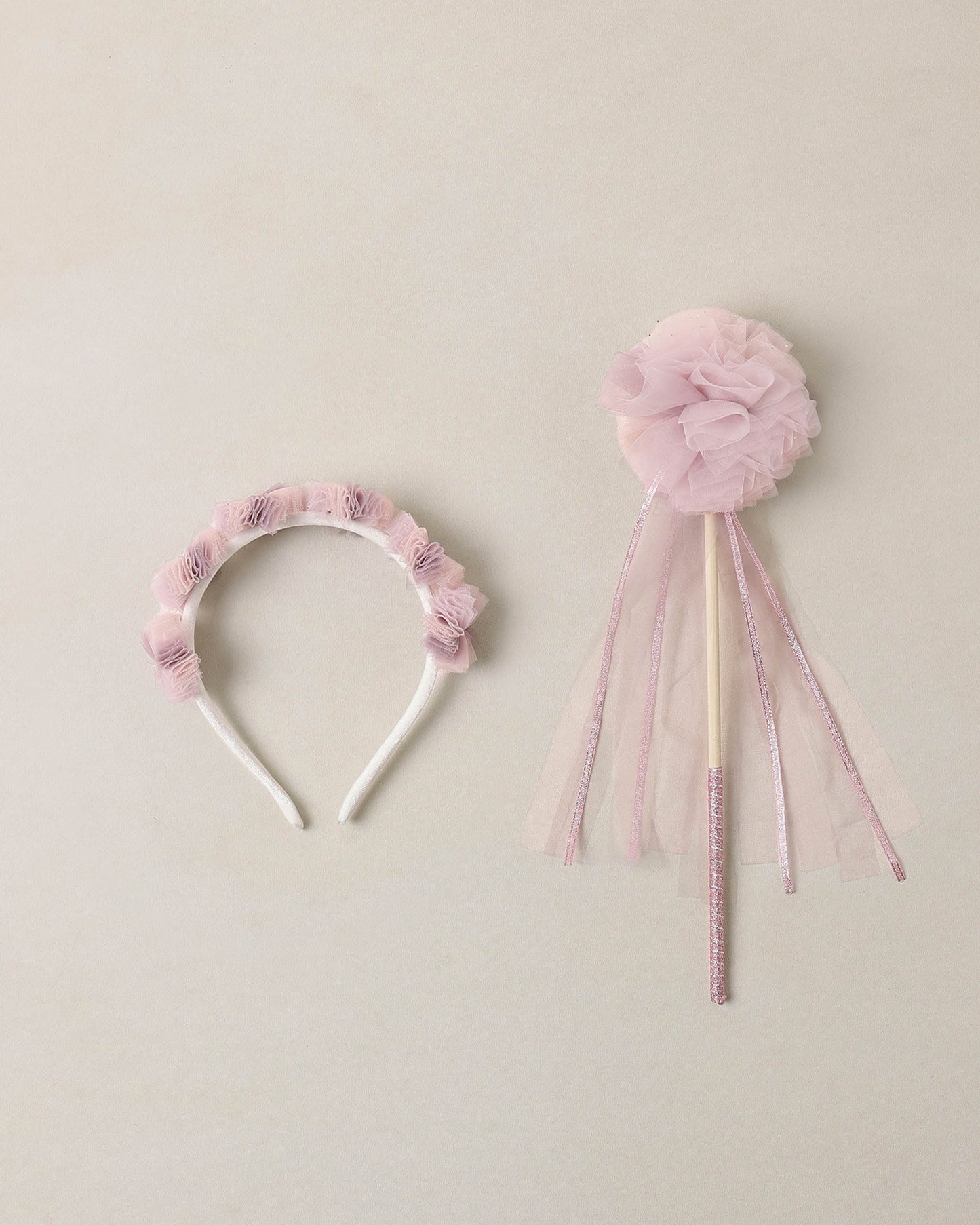 Pink tulle headband and matching wand on a beige background