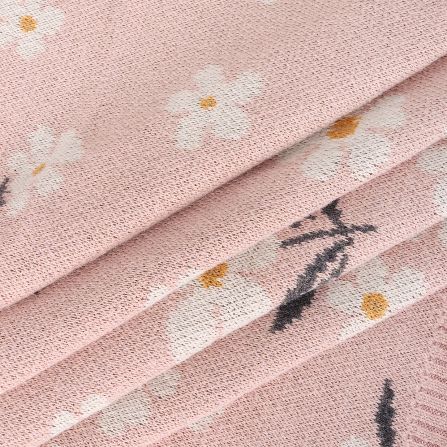 Close-up of pink blanket with floral embroidery