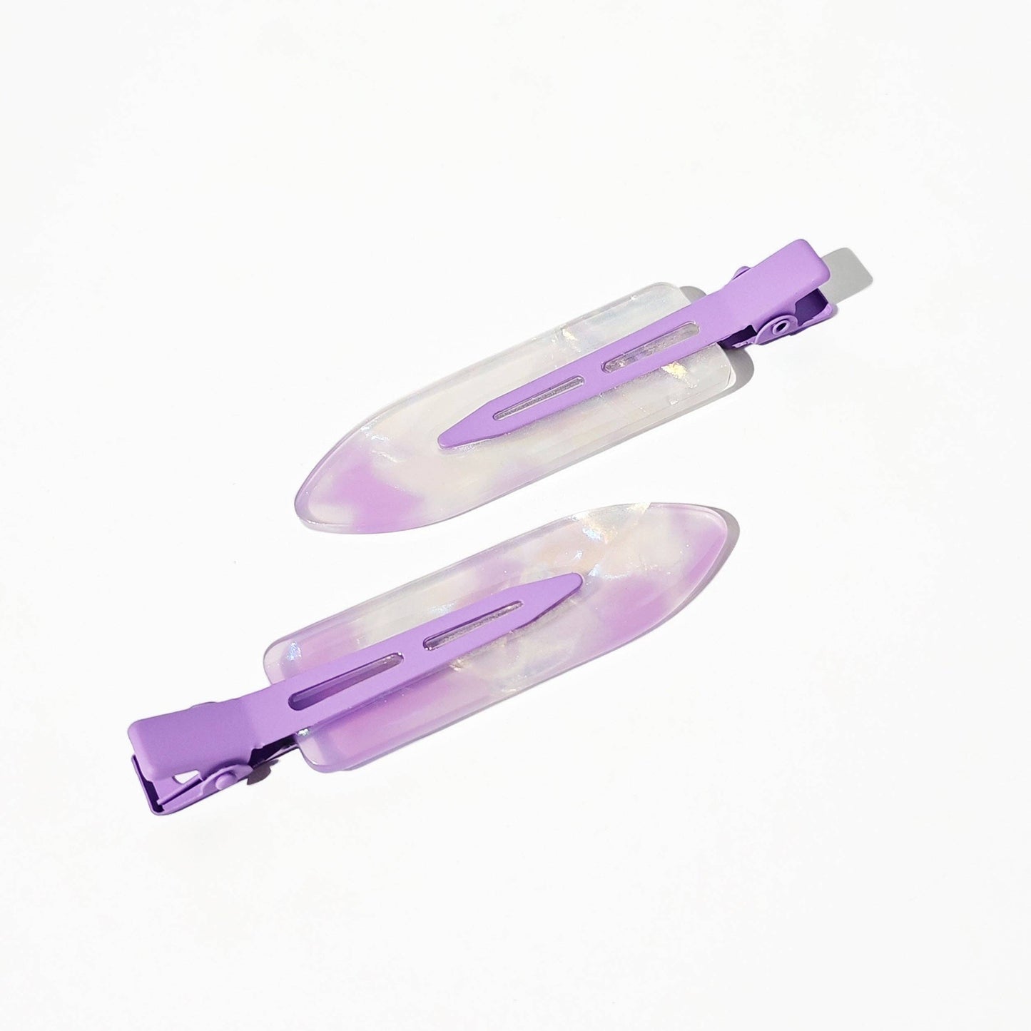 Two purple and clear hair clips on a white background