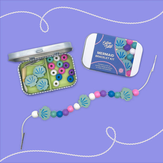 Mermaid bracelet kit with beads and packaging on a purple background