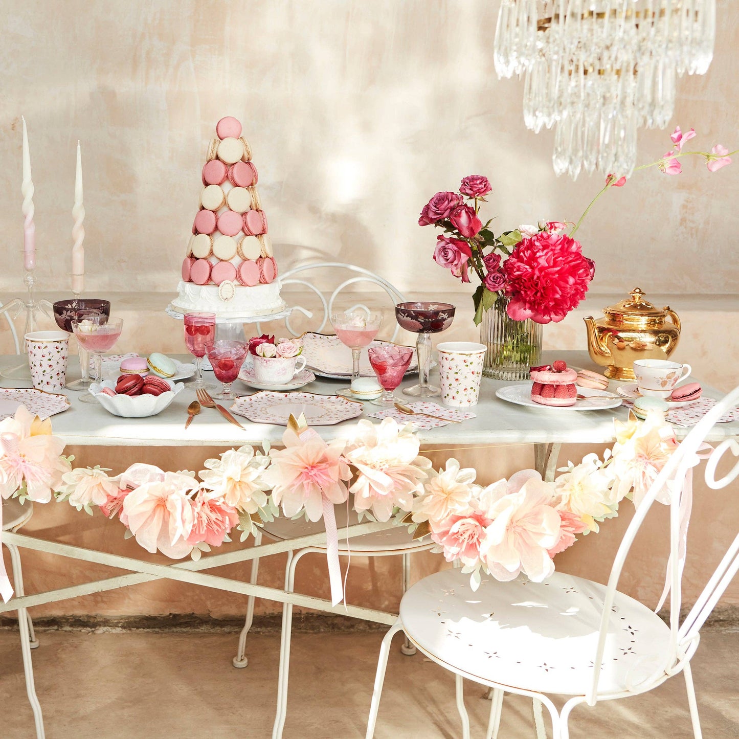 Decorative table setting with flowers, cake, and tea set in a elegant room.