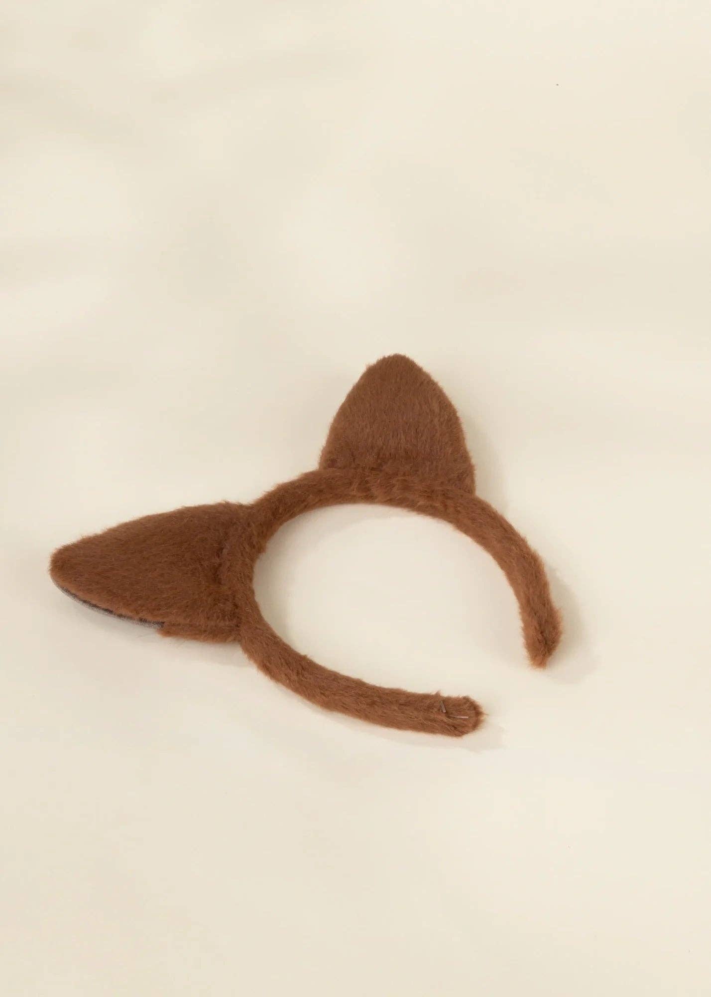 Brown felt fox ears headband on a light cream background.