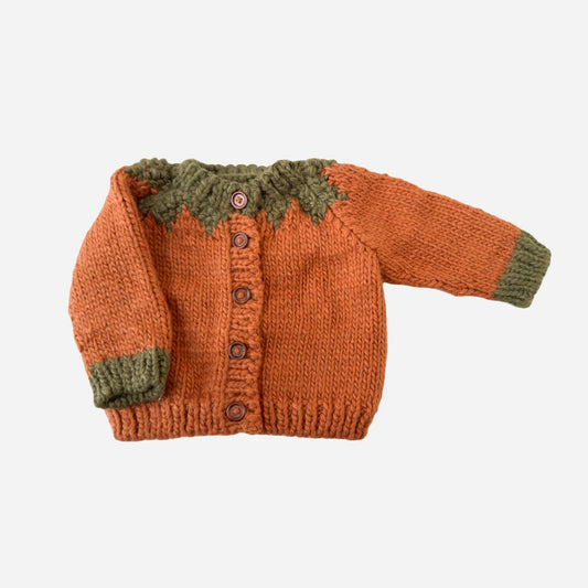 Knitted orange sweater with green trim on a white background