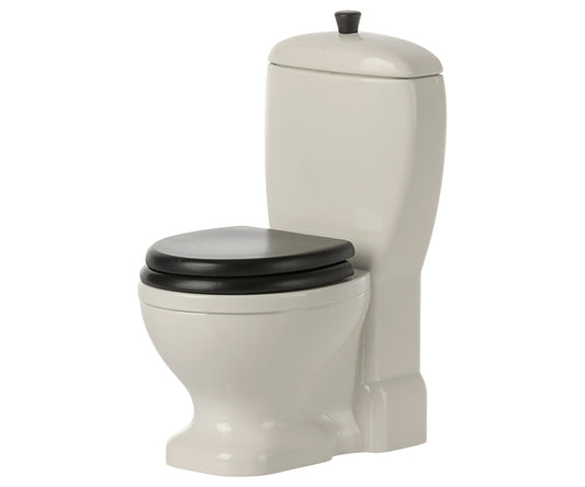 Beige dollhouse toilet with black seat on a white background