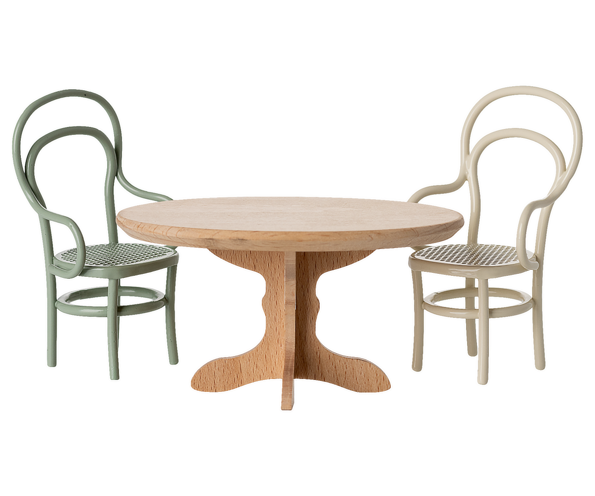 wooden dollhouse table with a mint colored chair and a white chair