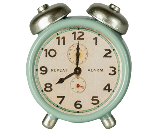 Vintage-style alarm clock with a light green casing and silver bells on a white background.
