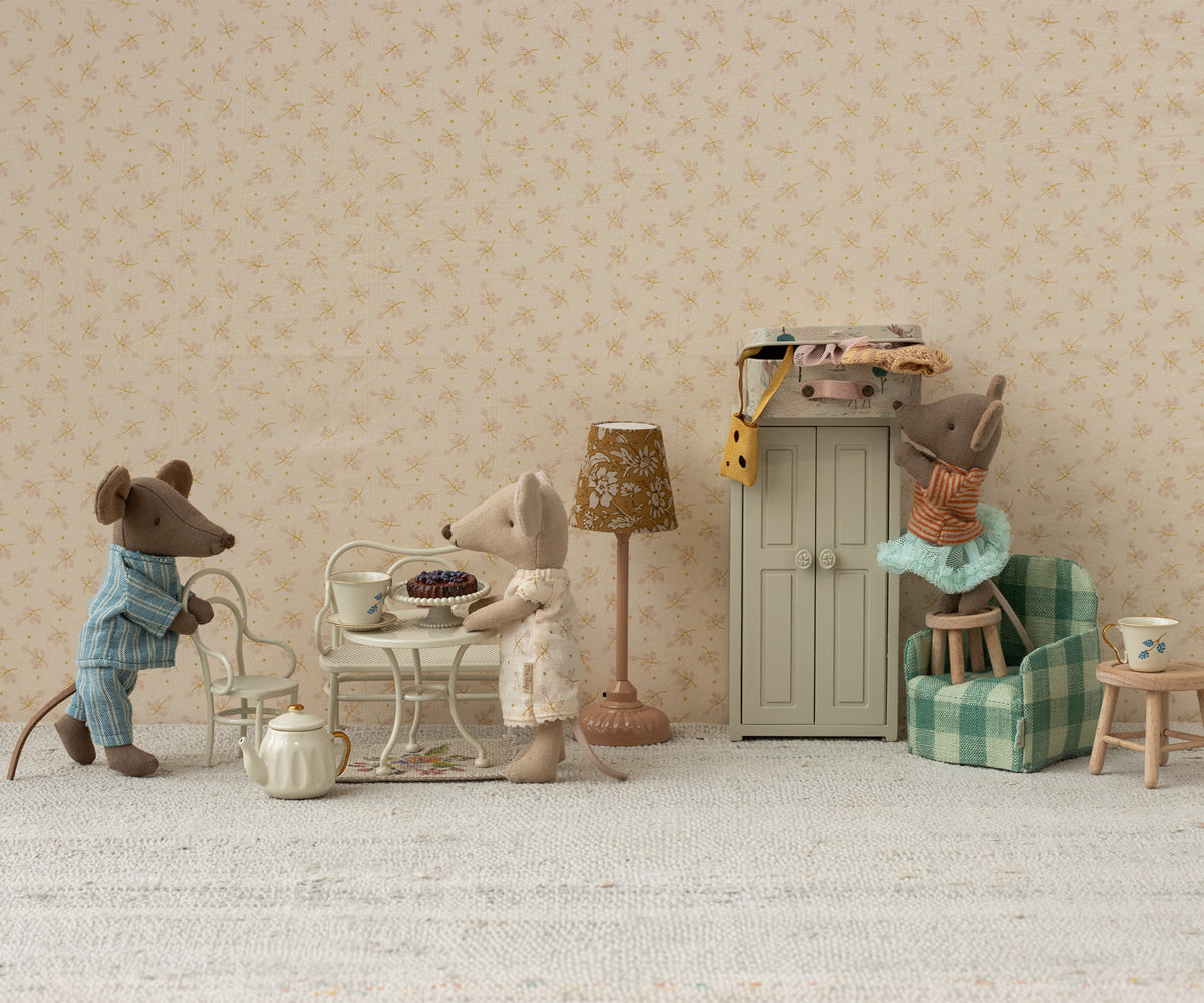 Miniature scene with toy mice in a room setting, including furniture and decor.
