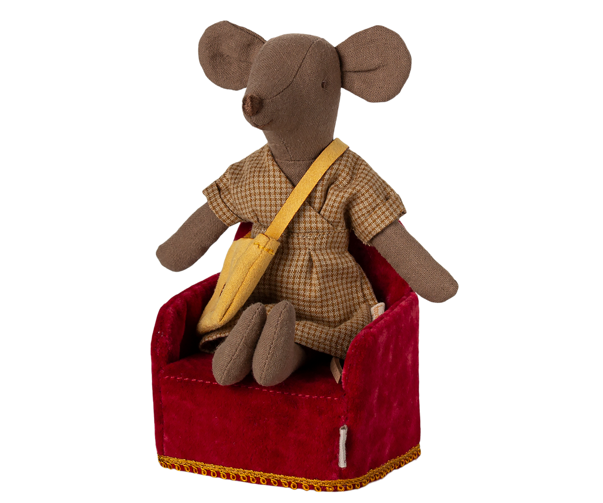 Stuffed mouse toy in a suit sitting on a red cushion with a white background