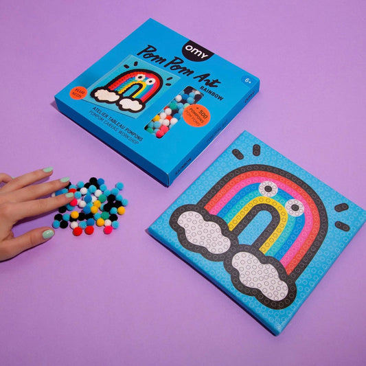 Pom pom art kit with rainbow design on a purple background