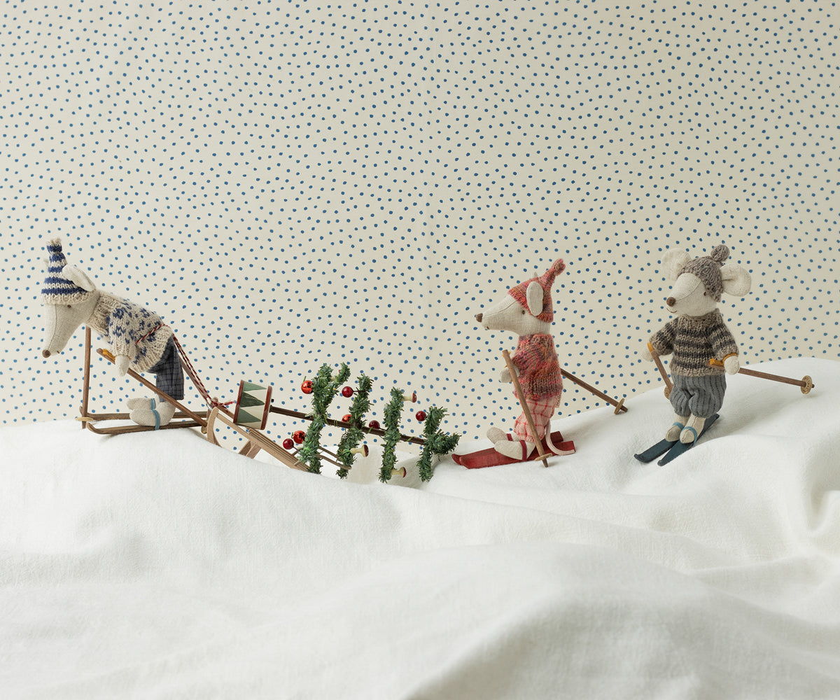 Three toy animals on a snowy landscape with a patterned background
