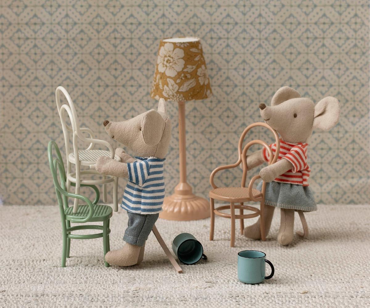 Maileg mice LouiMax and his sister Stella. Both wear striped shirts. In a living room setting with chairs, a lamp and cups. 