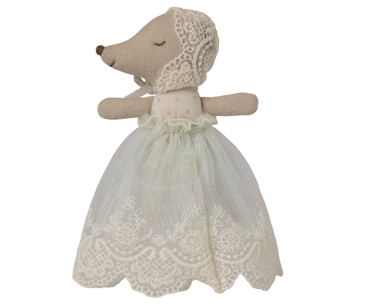 Stuffed animal toy with a lace dress on a white background, with eyes shut