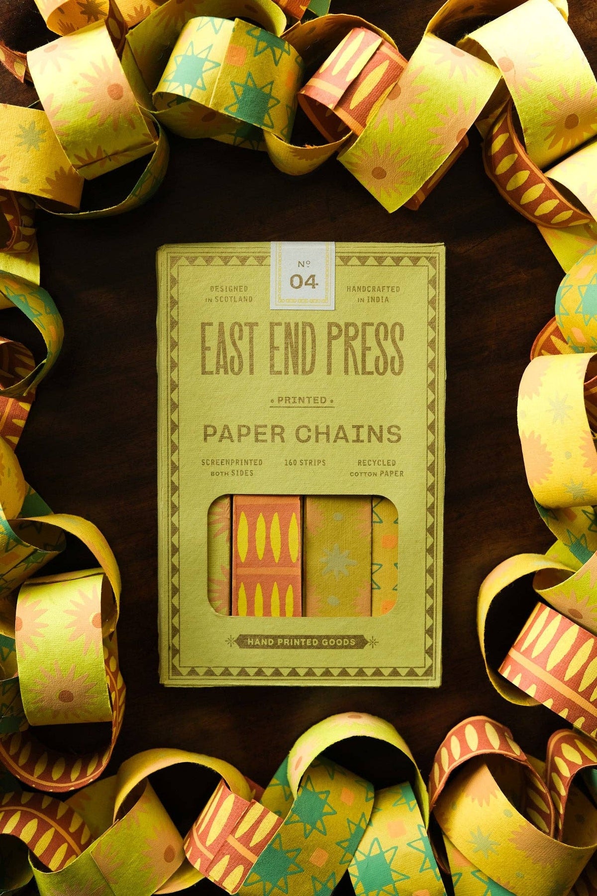 East End Press Yellow & Green Paper Chain Kit with assembled patterned links on a wooden surface.