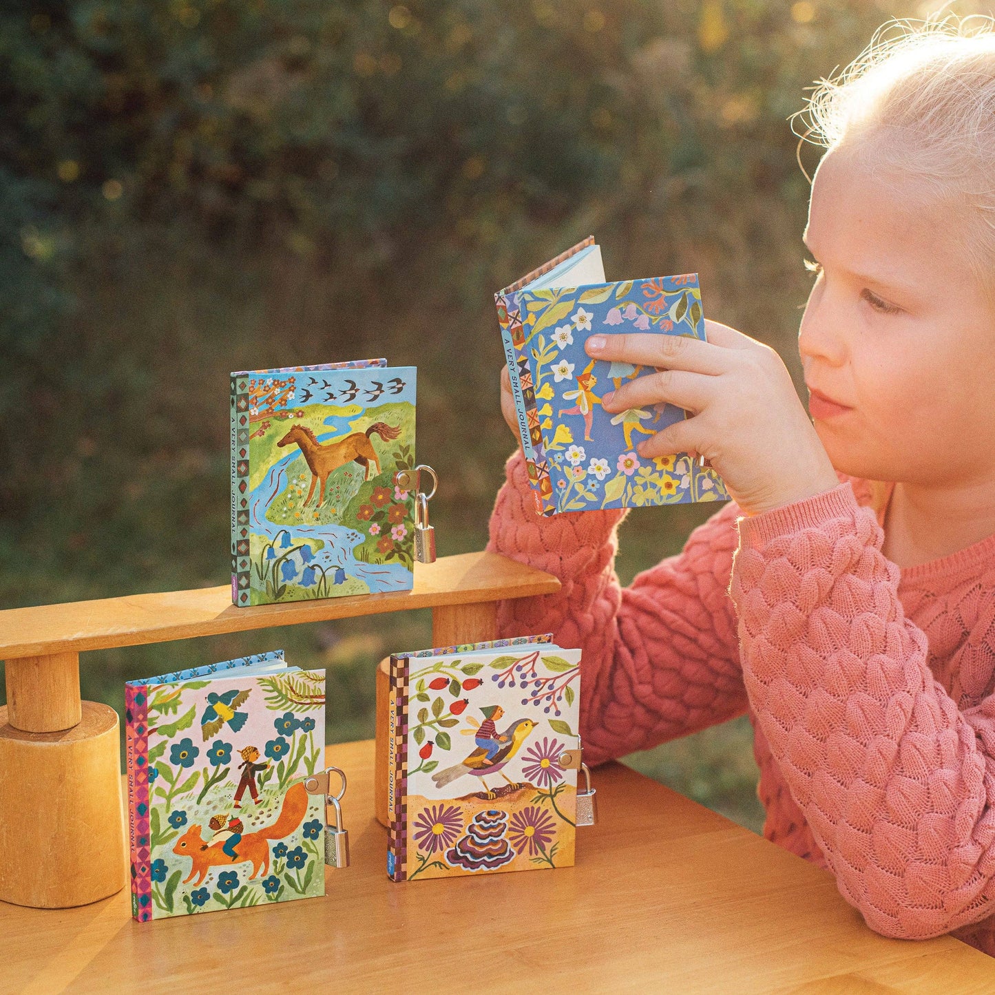 Four colorful lockets with animal-themed designs and a little child reading one journal

