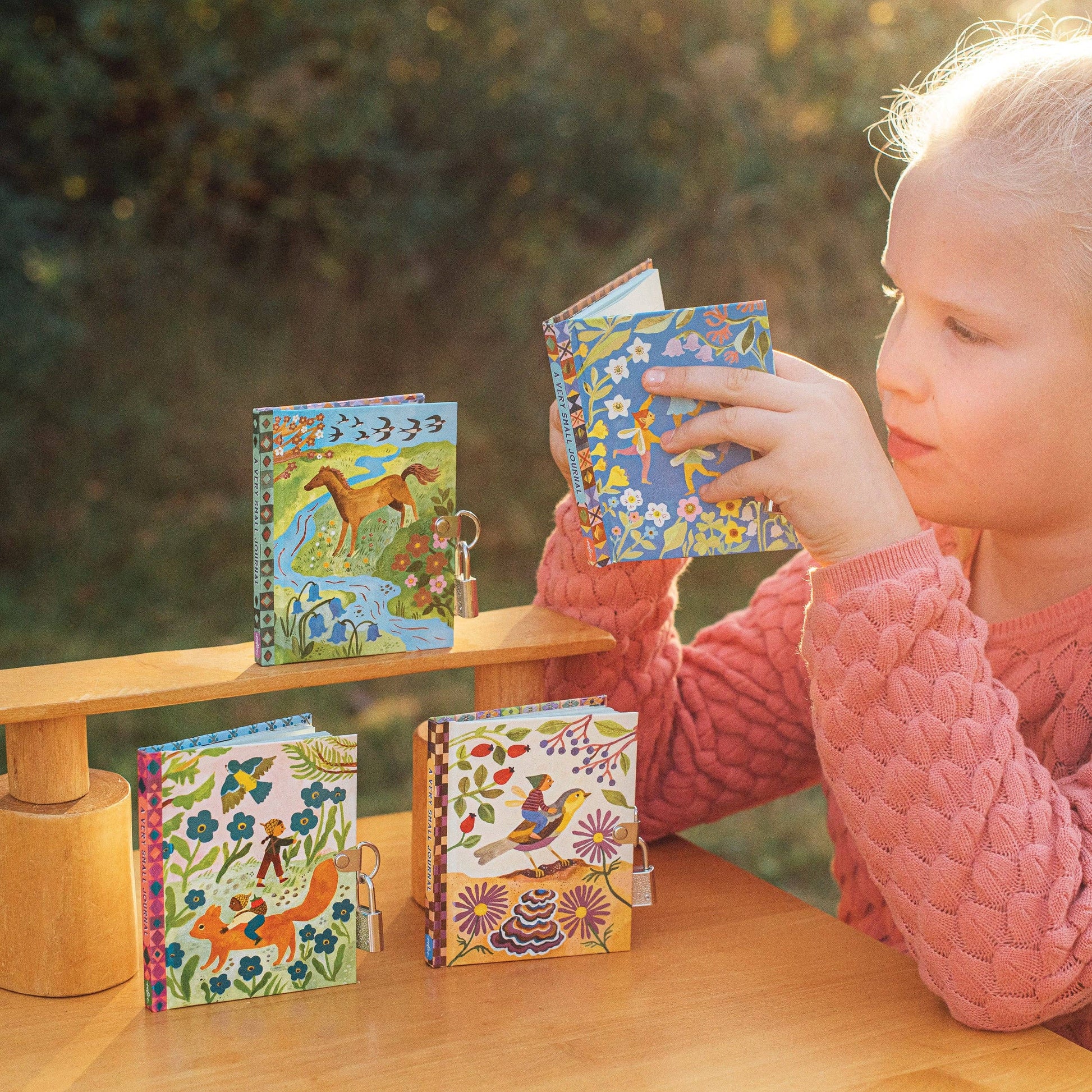 Four colorful lockets with animal-themed designs and a little child reading one journal

