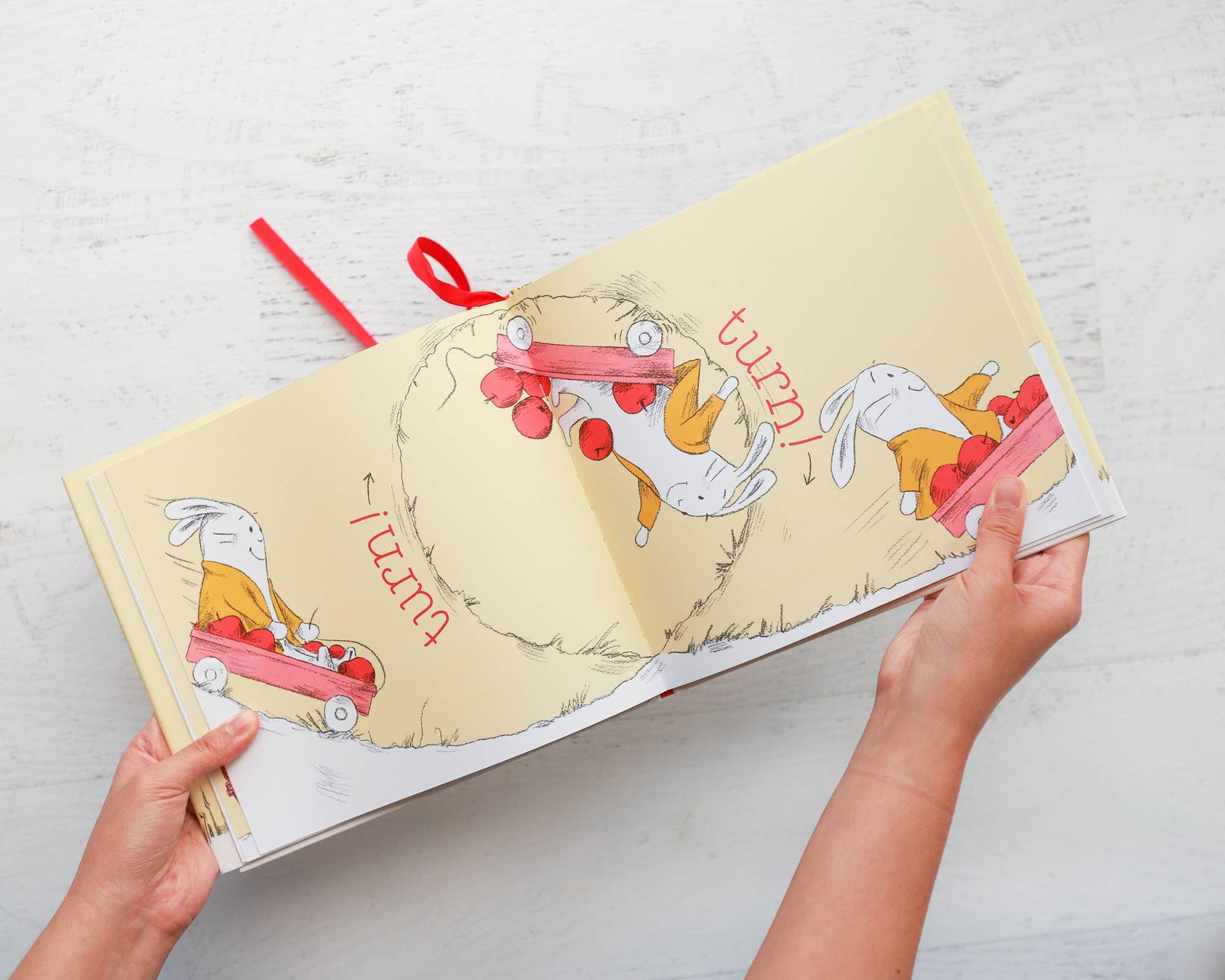 Open book with cartoon characters and text on a light wooden surface