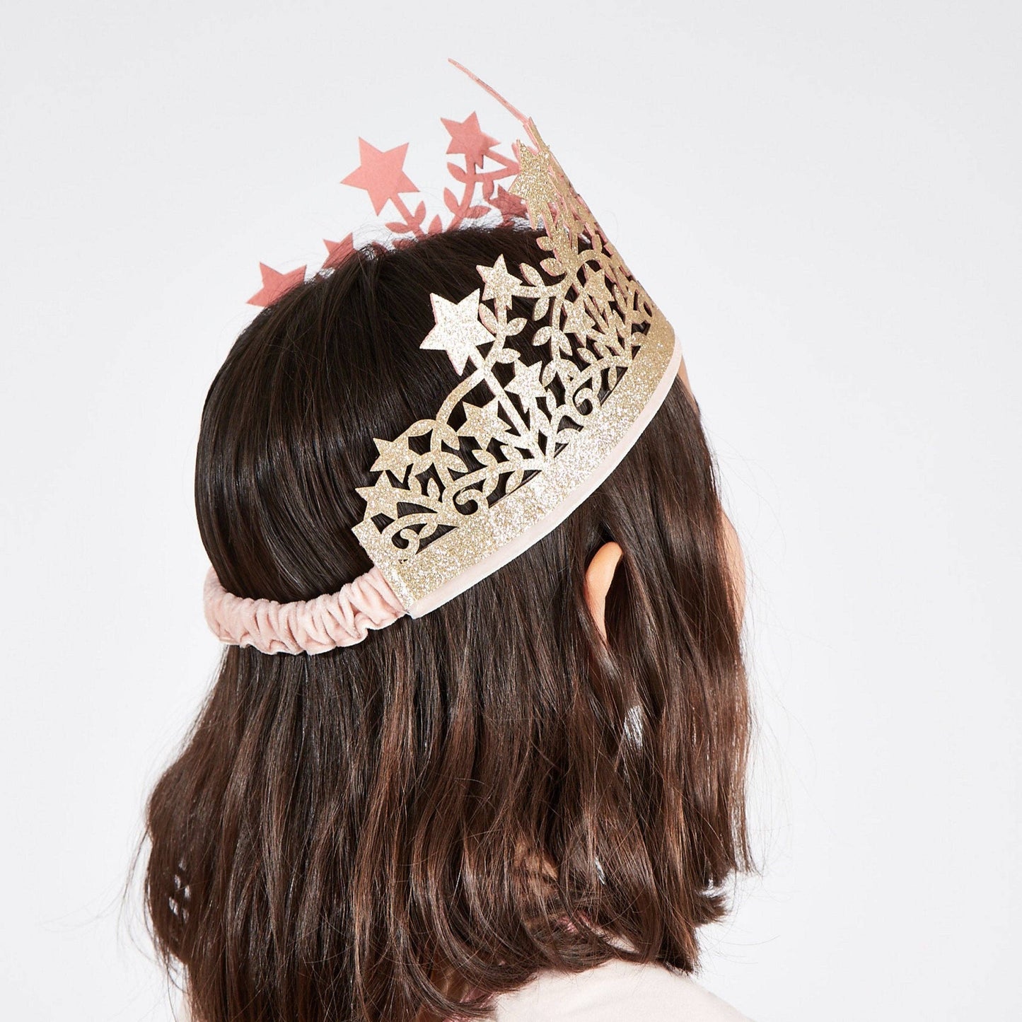 Person wearing a decorative headband with stars on a plain background