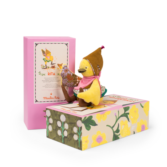 Small yellow bird figurine with a brown hat and pink scarf on a decorative box with floral design.