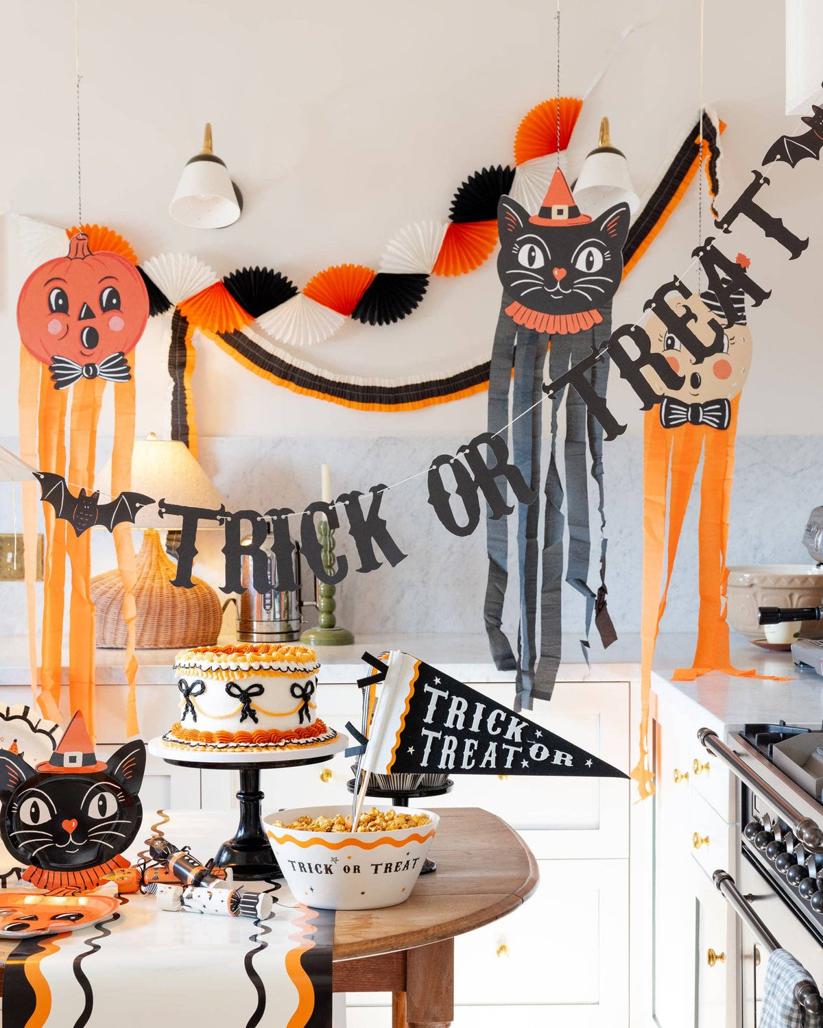 Halloween-themed decorations including a cat, pumpkin, and 'Trick or Treat' banner in a kitchen.