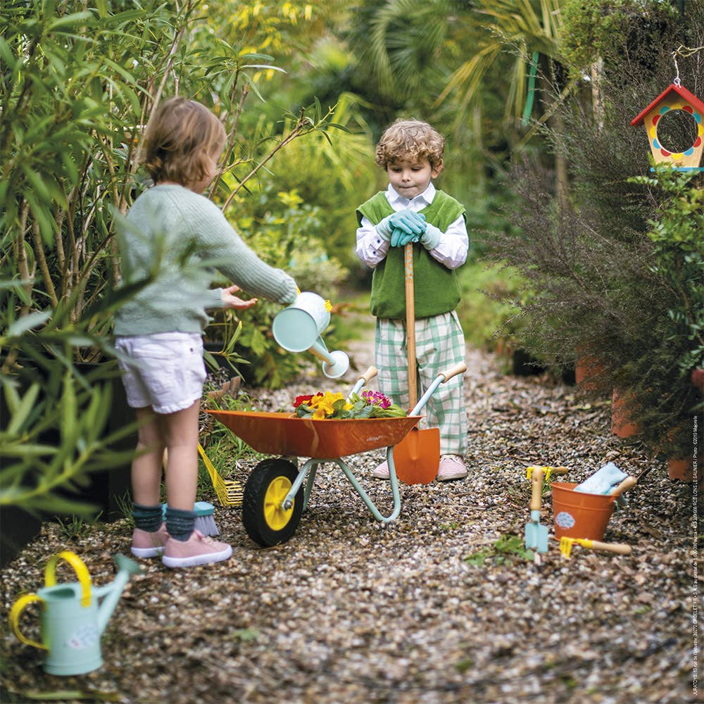Two children gardening in a garden with tools and plants.