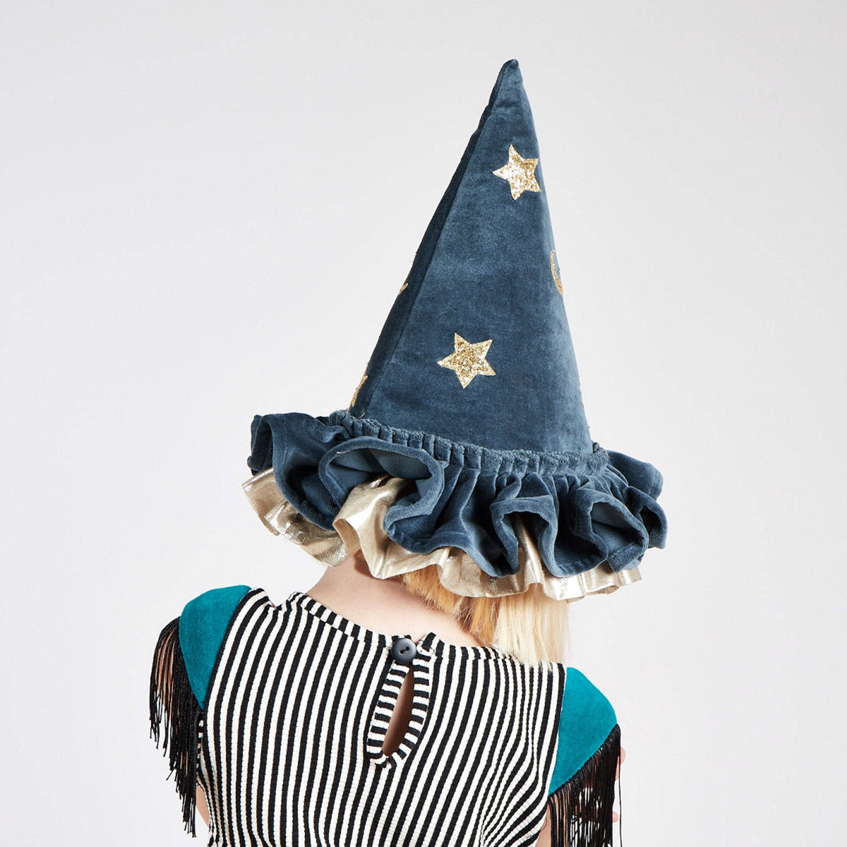 Person wearing a blue wizard hat with star patterns on a white background