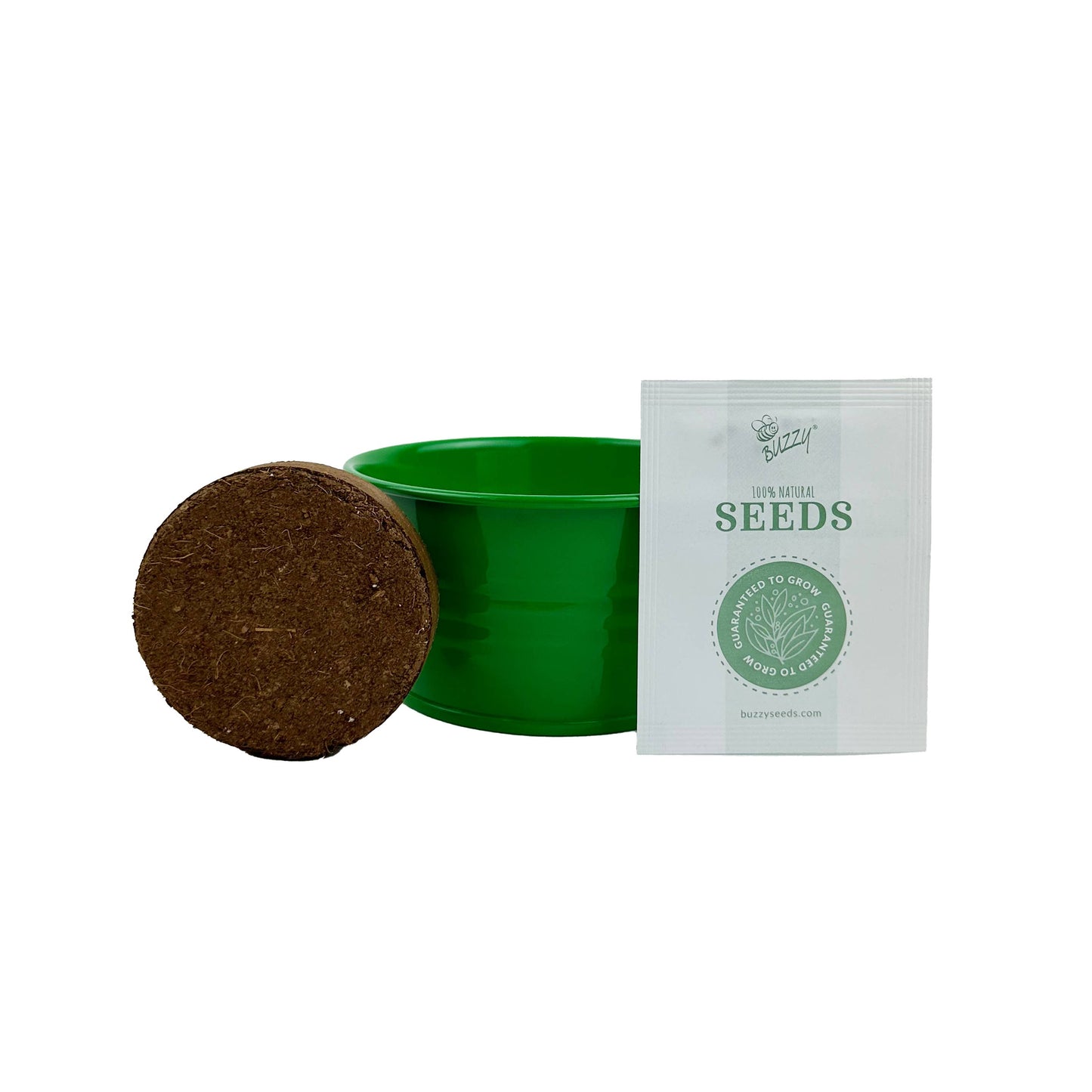 Green seedling pot, growing medium pellet, and white seed packet on a white background