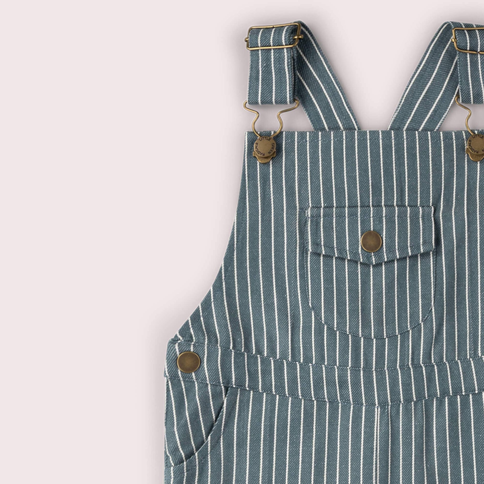Blue and white striped overalls with button details on a light gray background