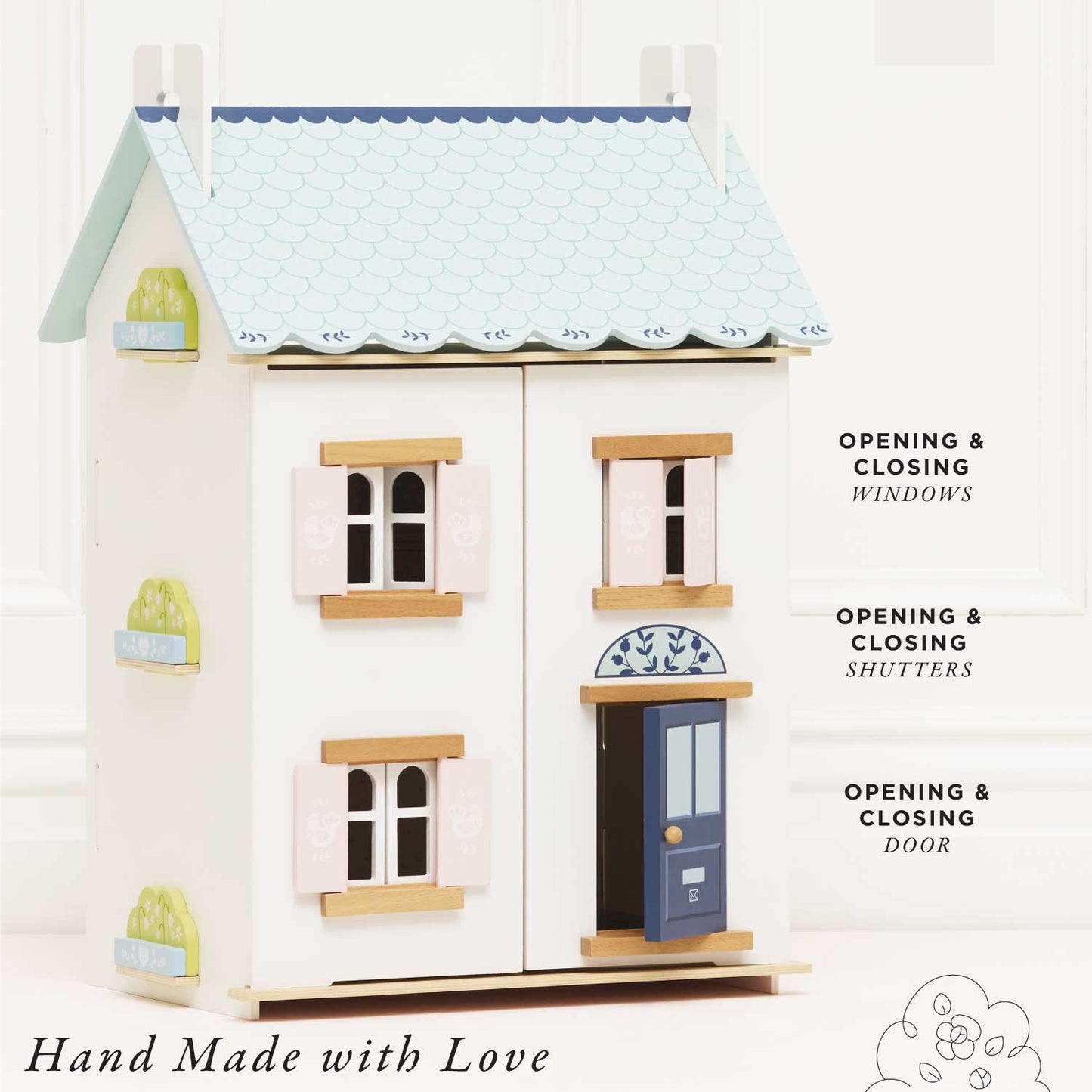 Toy dollhouse with opening doors, windows, and shutters on a white background