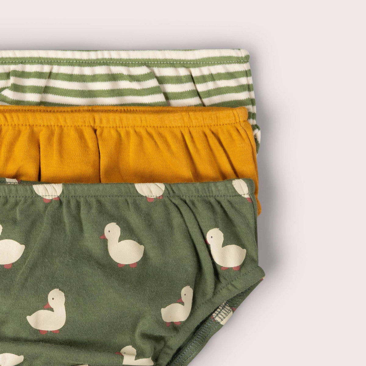 Detail of elastic waistbands on olive duck-print, mustard and green striped underwear.
