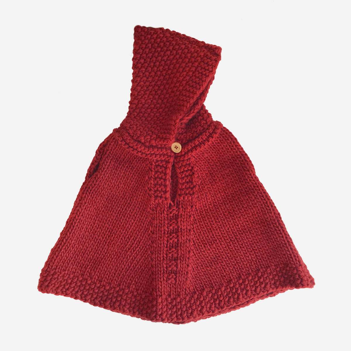 Red knitted poncho with a hood on a white background
