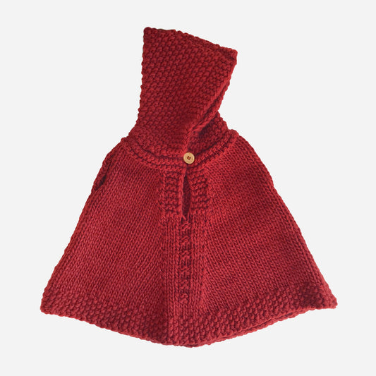 Red knitted poncho with a hood on a white background
