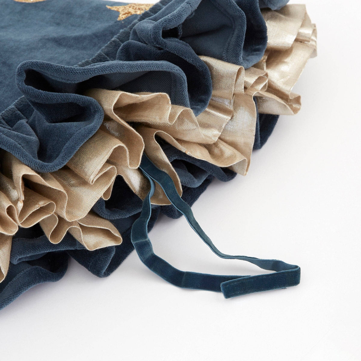 Close up of blue and beige fabric hat ruffles on a white background