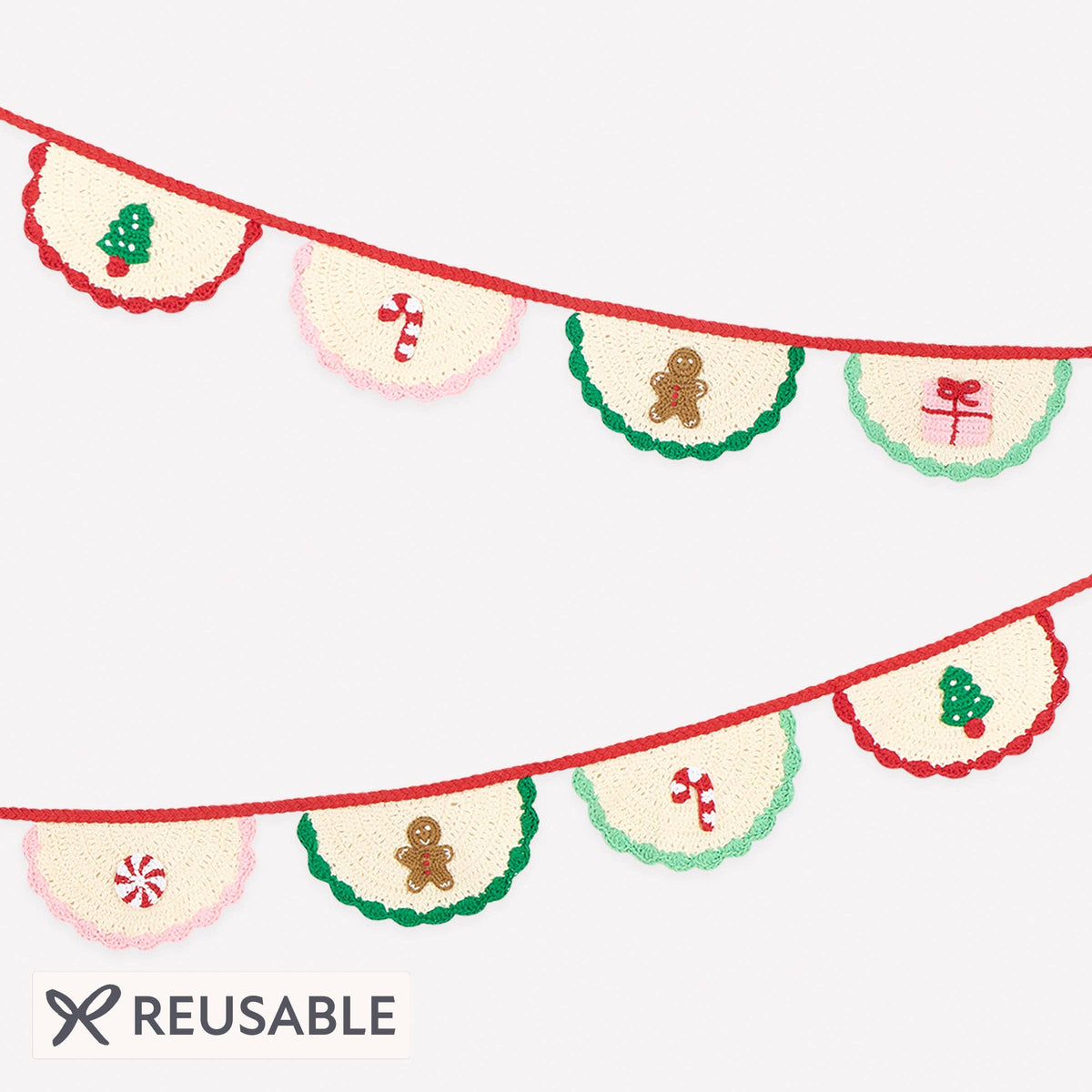 A festive reusable bunting banner with embroidered holiday motifs, featuring cream-colored fan-shaped pennants strung along red cords. The designs include green borders, candy canes, gingerbread men, and Christmas trees, shown on a light gray background with a 'REUSABLE' label at the bottom.