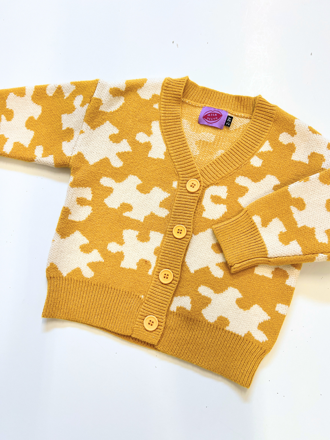 Yellow cardigan with white pattern on a white background
