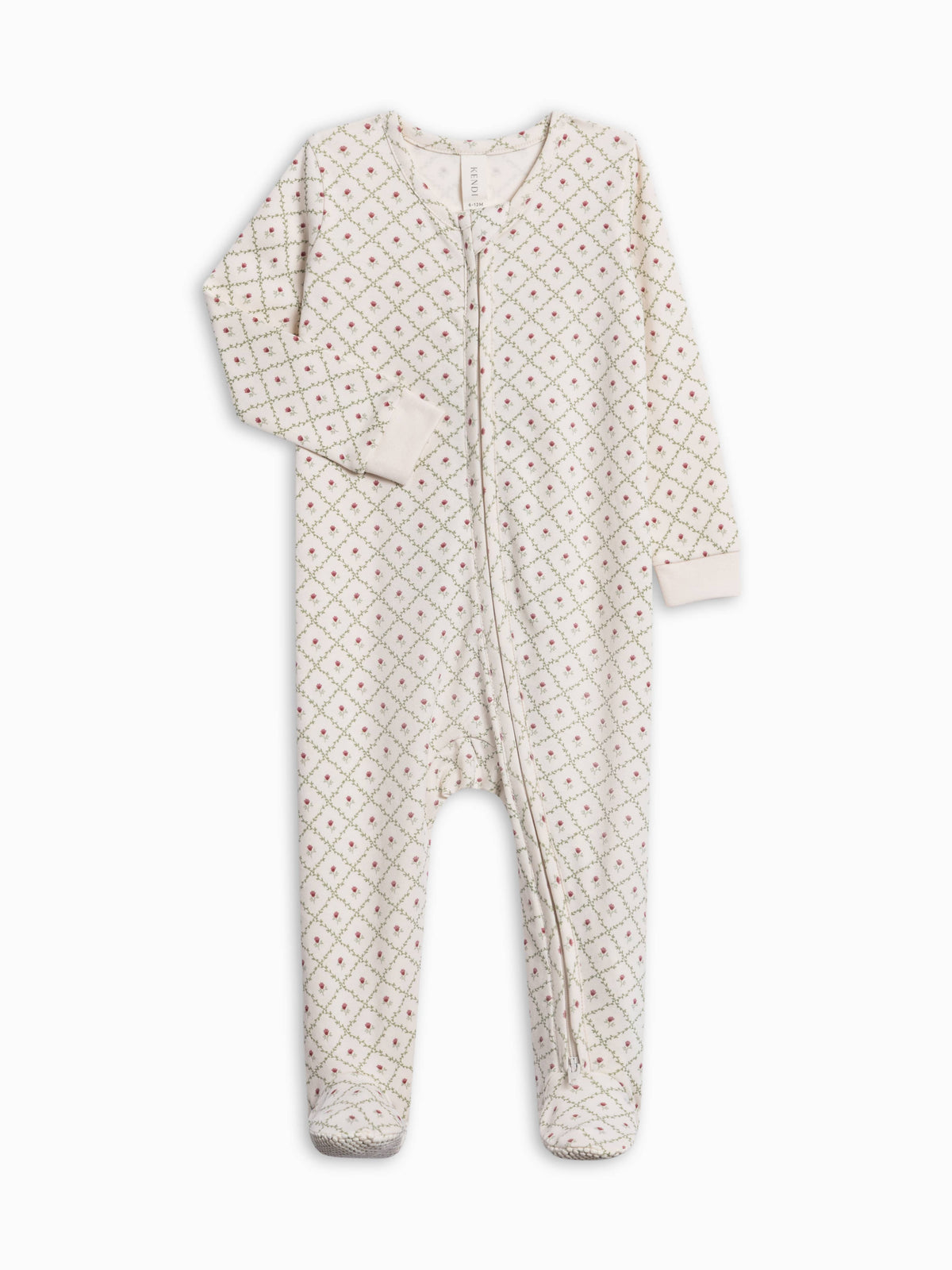 A baby footed one-piece sleeper in cream with a small repeating red and green floral pattern, featuring a front zipper closure and long sleeves.