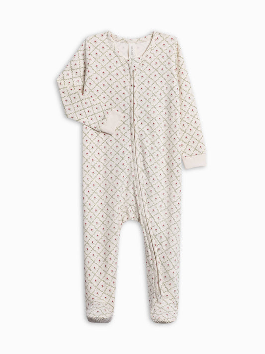 A baby footed one-piece sleeper in cream with a small repeating red and green floral pattern, featuring a front zipper closure and long sleeves.