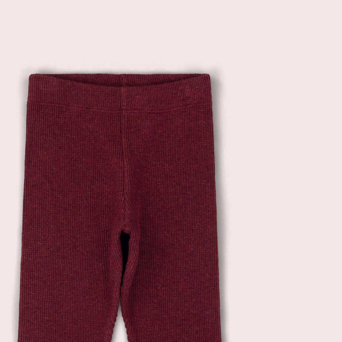 Close-up of the elastic waistband and waffle texture on burgundy leggings.