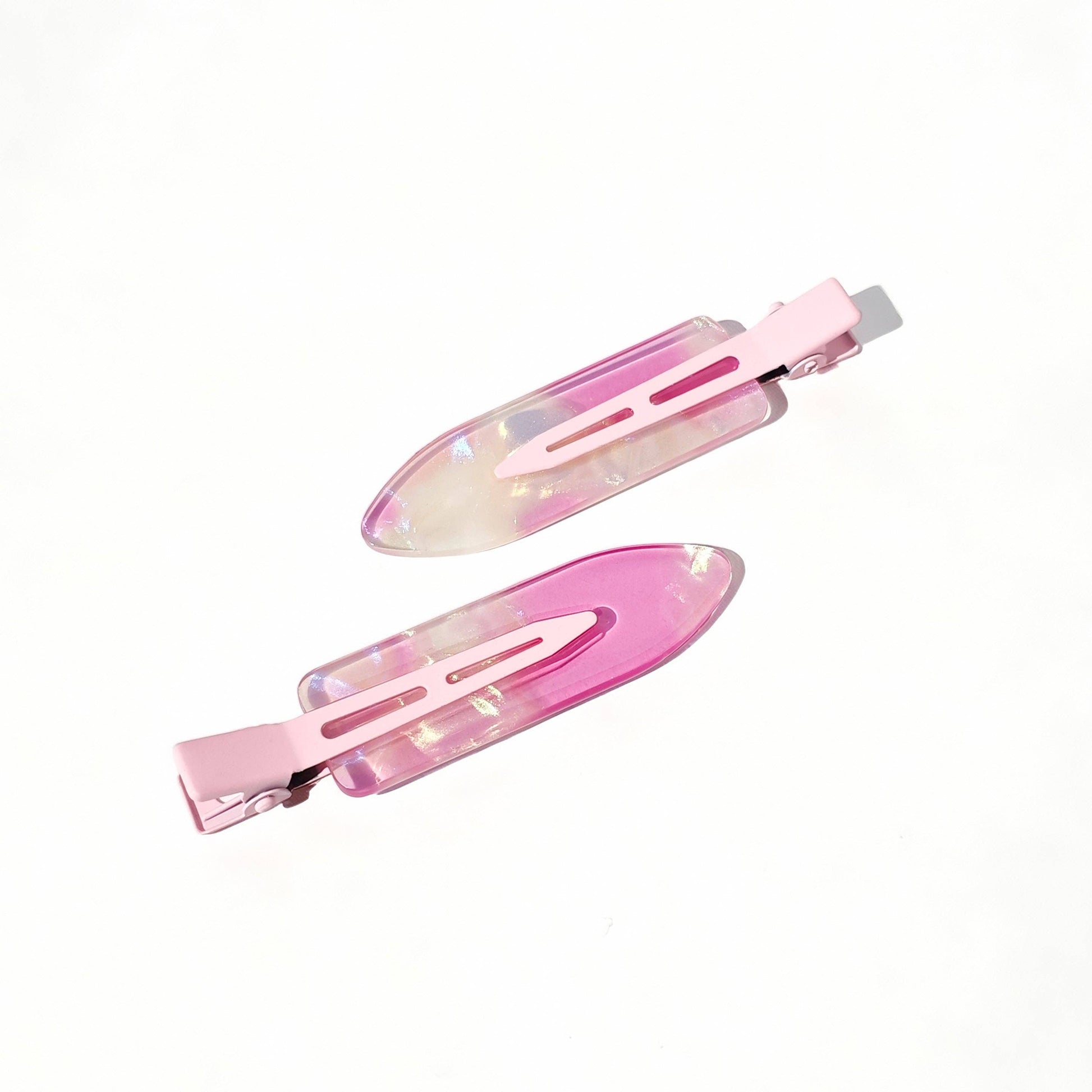 Two pink hair clips with a metallic sheen on a white background