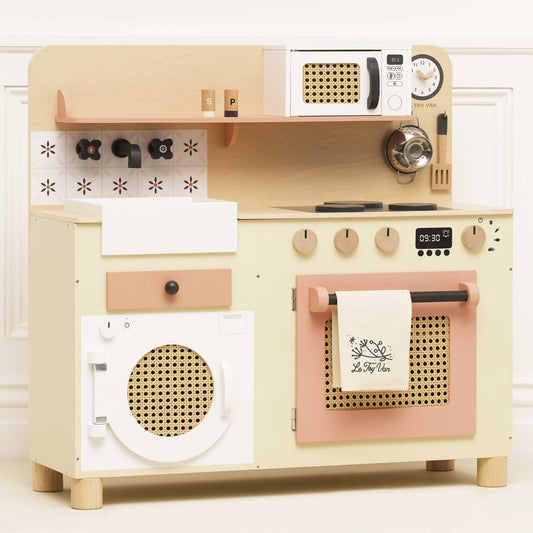Wooden toy kitchen set with beige and pink appliances on a white background