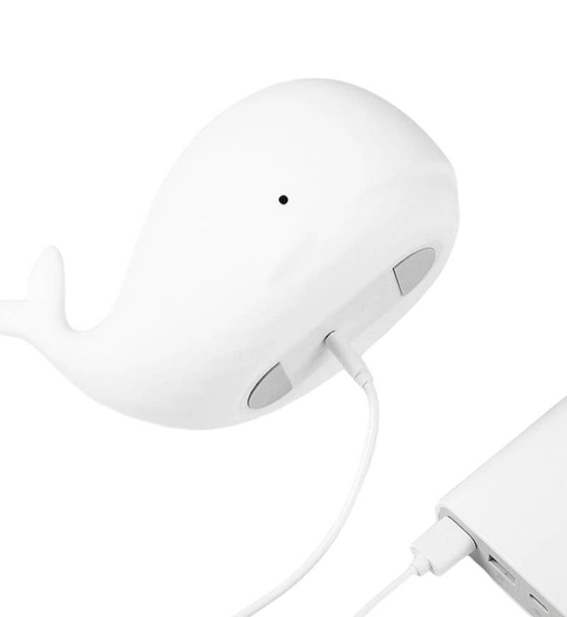 Whale shaped lamp with charging cable on a white background