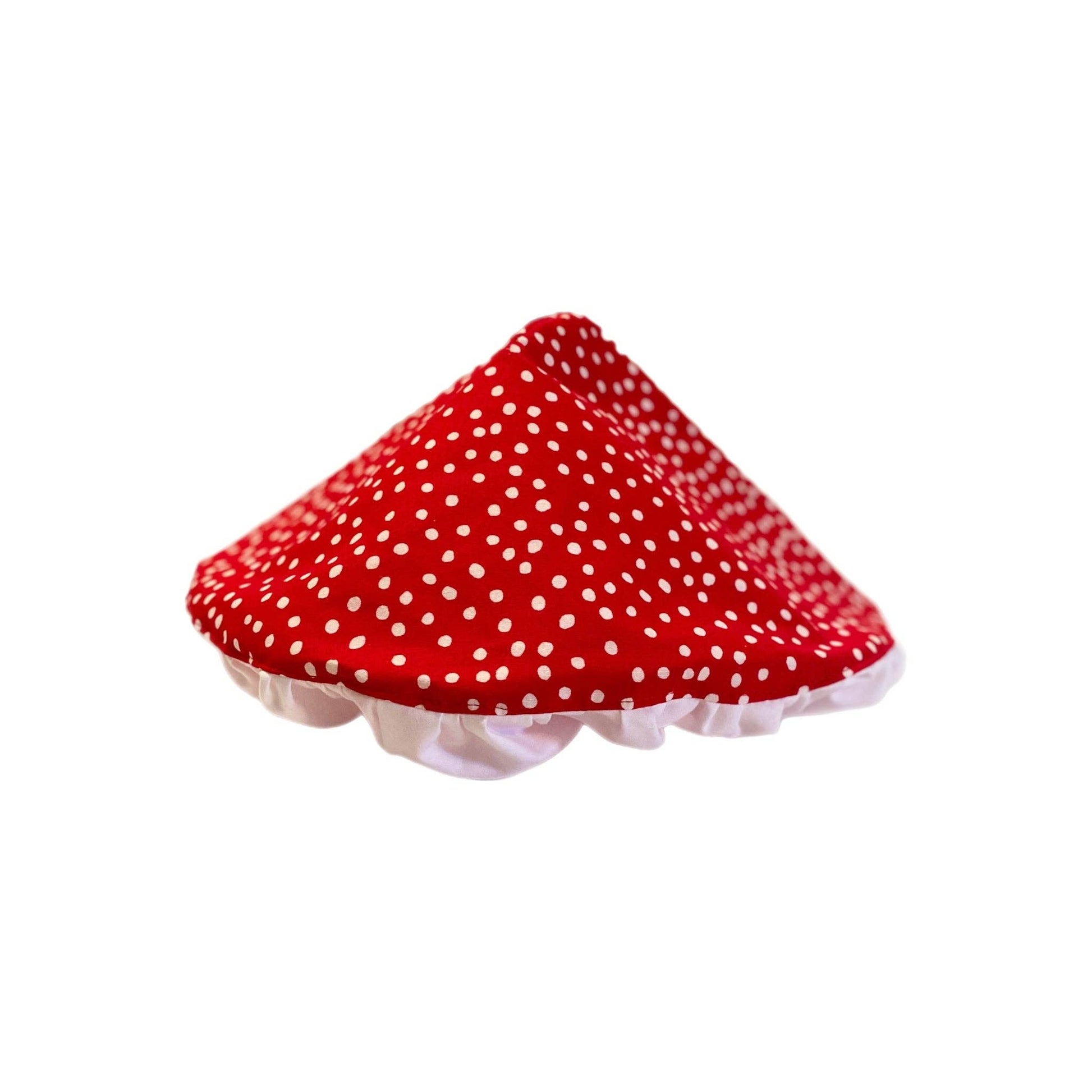 Red polka dot mushroom shaped hat with a white edge on a white background