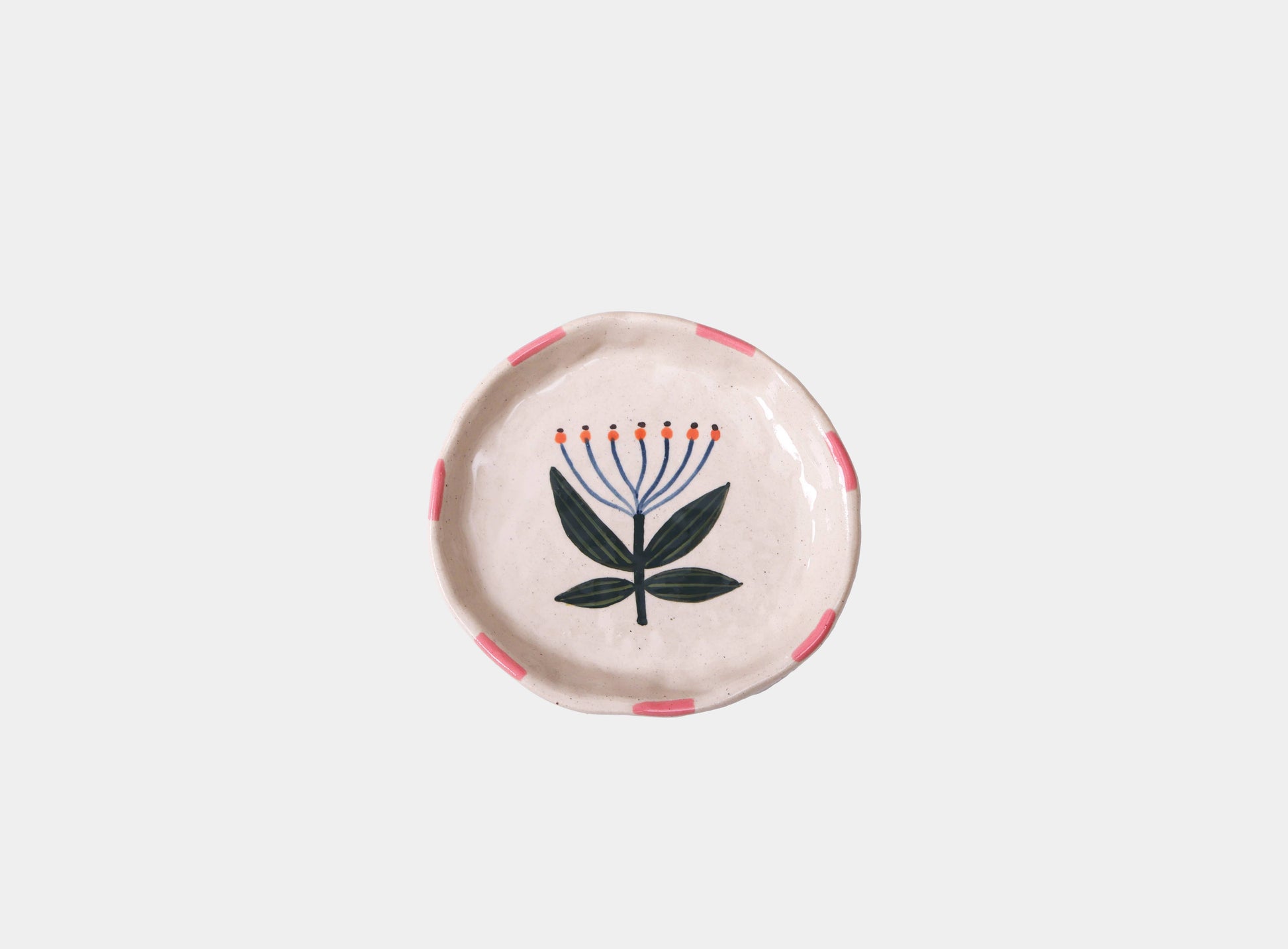 Round ceramic plate with floral design on a light gray background